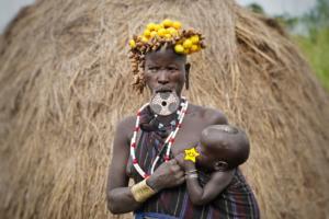 Mursi Tribe lady with Lip plate feeding her baby